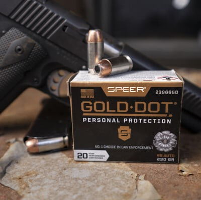 Gold Dot cartridges and box on a table with a handgun