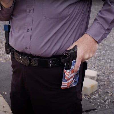 patrick kelley pulling his handgun from a belt holster