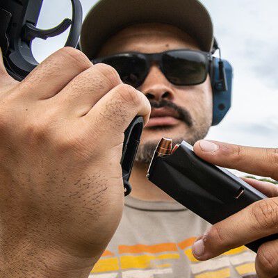 Man loading pistol outside