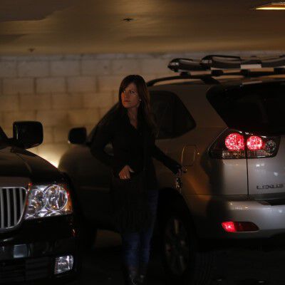 Lady standing in a parking ramp grabbing a pistol out of her purse