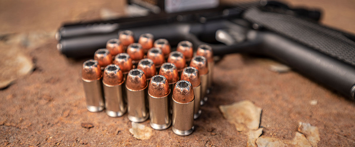 Speer Gold Dot cartridges sitting on a table with a gun