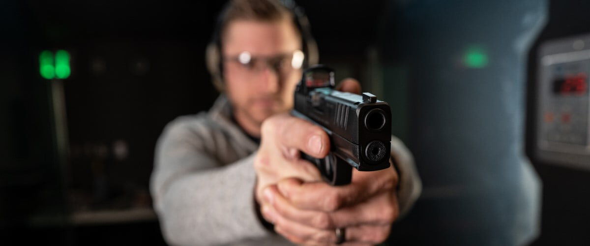 shooter in an indoor range aiming handgun