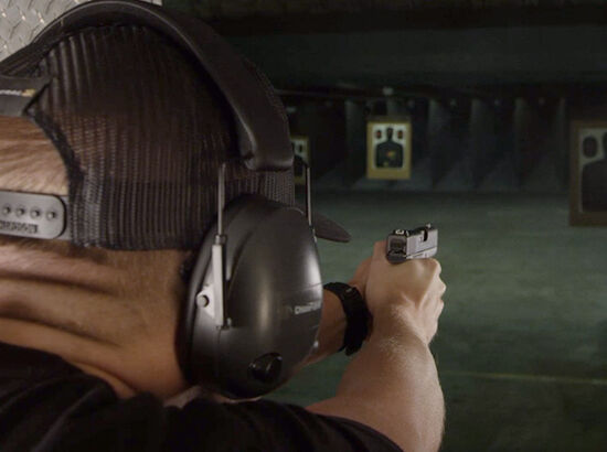 Person Shooting Handgun at Gun Range