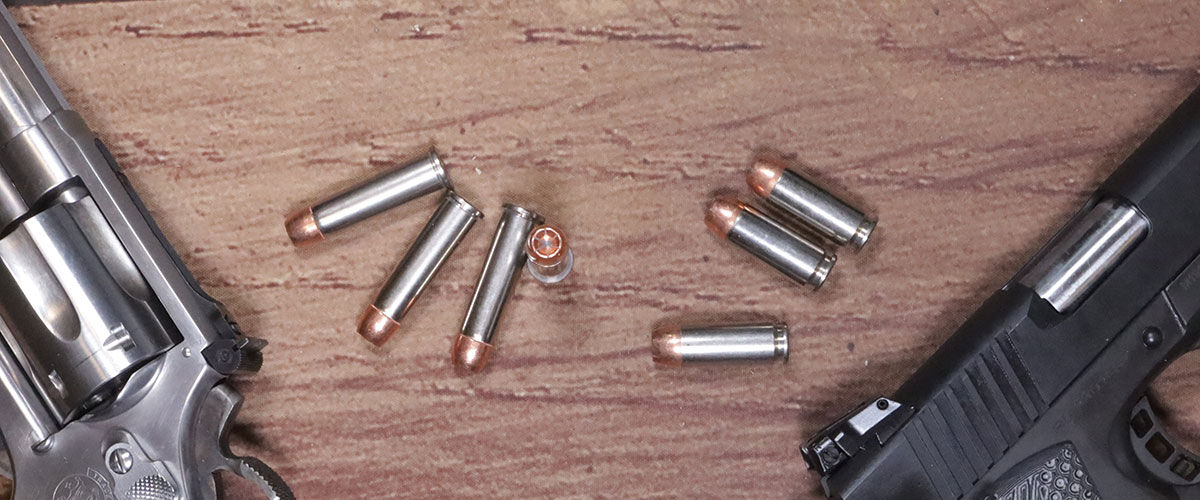 Speer ammo and two guns laying on a table