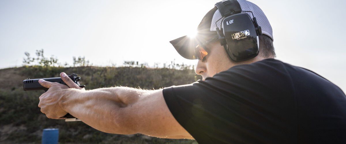 man pointing a pistol outside