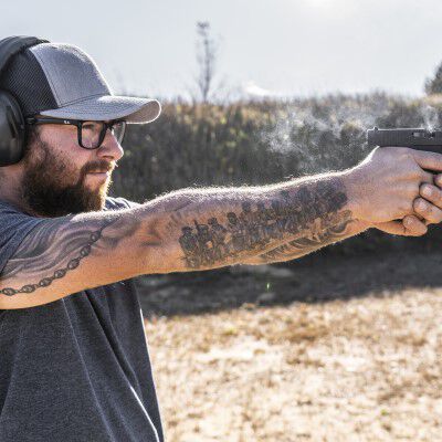 Person pointing a handgun outside