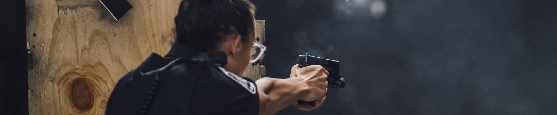 female officer shooting at a target at a range