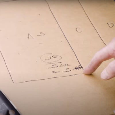 Patrick Kelley pointing at writing on a cardboard target