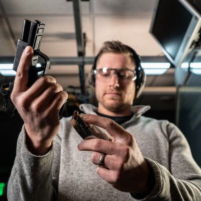 shooter loading a magazine into a pistol