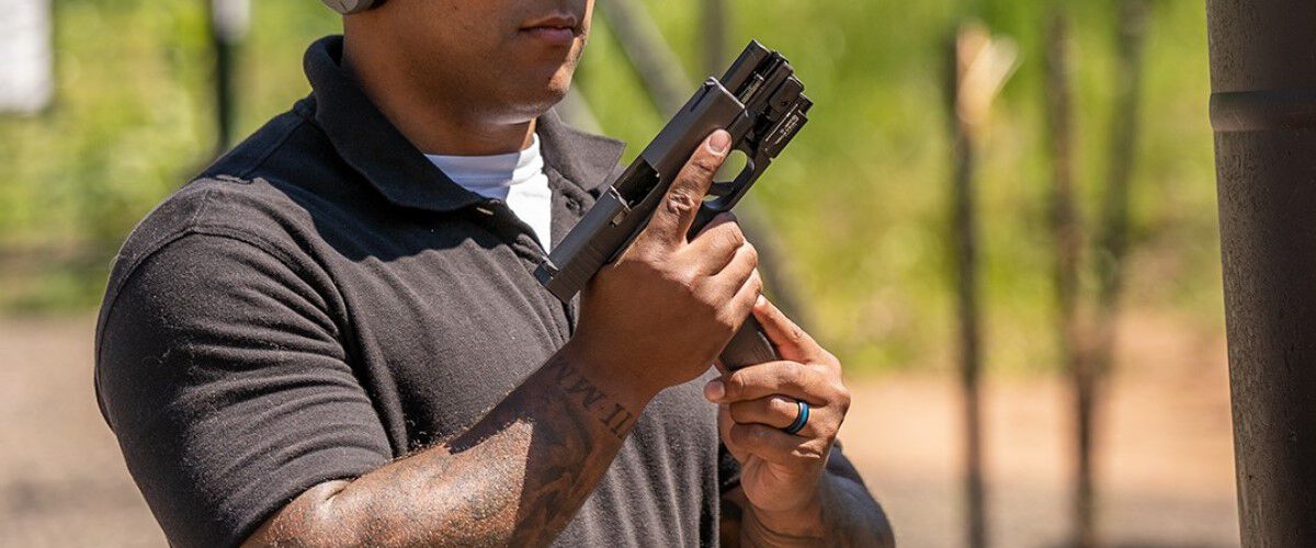 guy loading magazine into pistol 