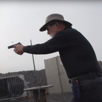 Patrick Kelley aiming a pistol while outside