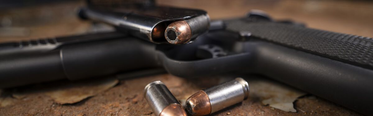 Speer bullets laying on a table beside a pistol