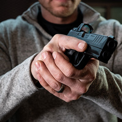 person holding handgun with both hands