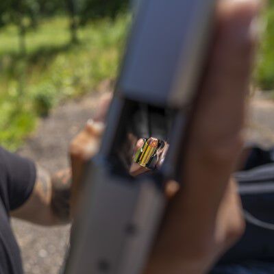 man loading magazine into handgun