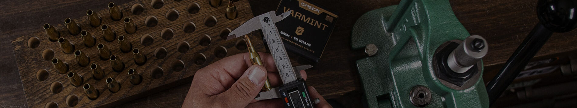 man measuring a loaded bullet