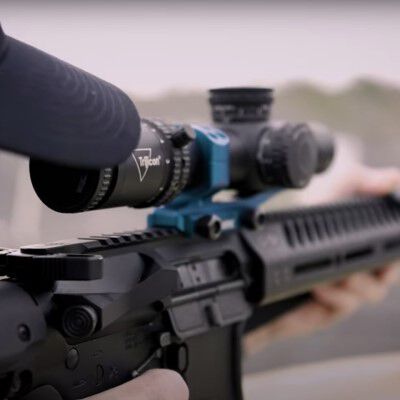 Patrick Kelley looking down the scope of a carbine