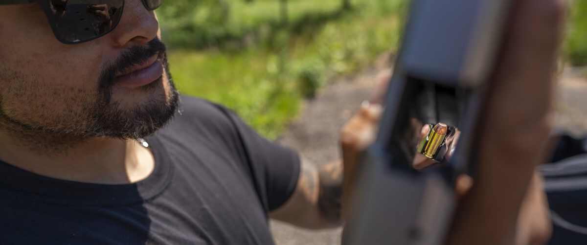 Man loading magazine into handgun