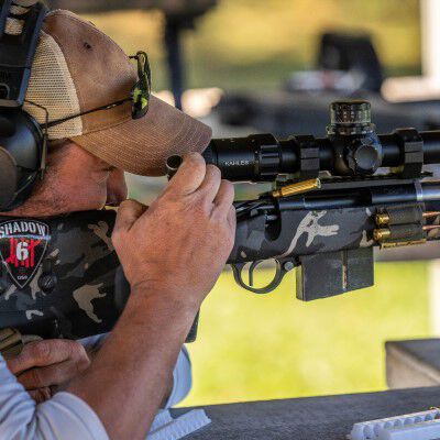 Jim Gilliland looking down the scope of a rifle