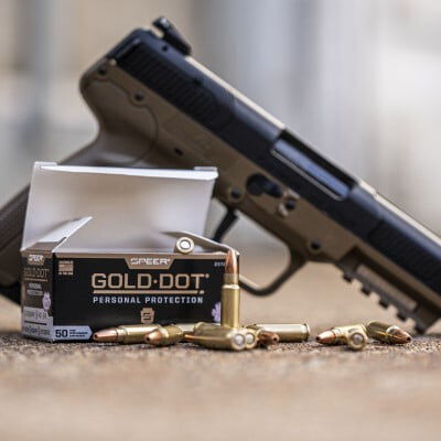 Speer Gold Dot Personal Protection box and cartridges on a table in front of a handgun