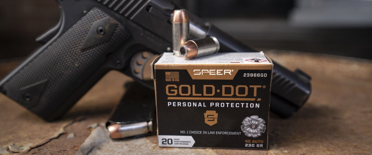 Gold Dot cartridges and box on a table with a handgun