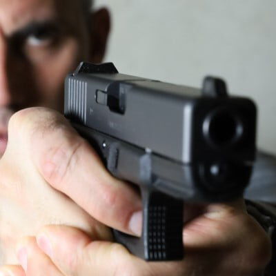 shooter looking down the iron sights of a pistol