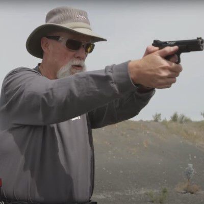 Patrick Kelley aiming a pistol