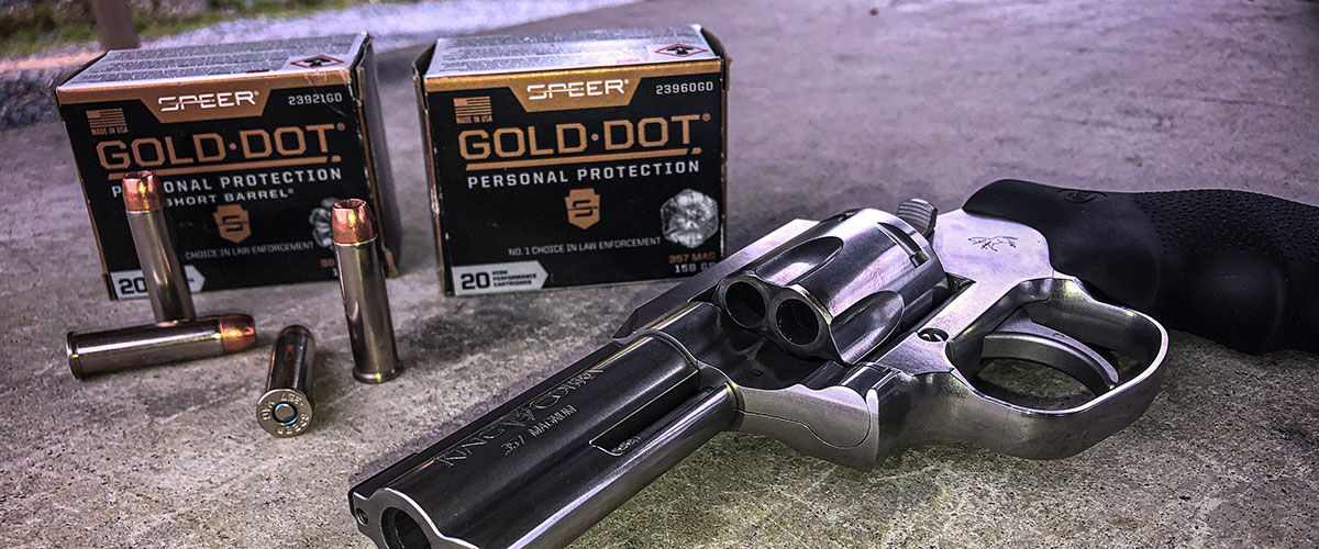 2 boxes of Gold Dot on the ground with a revolver