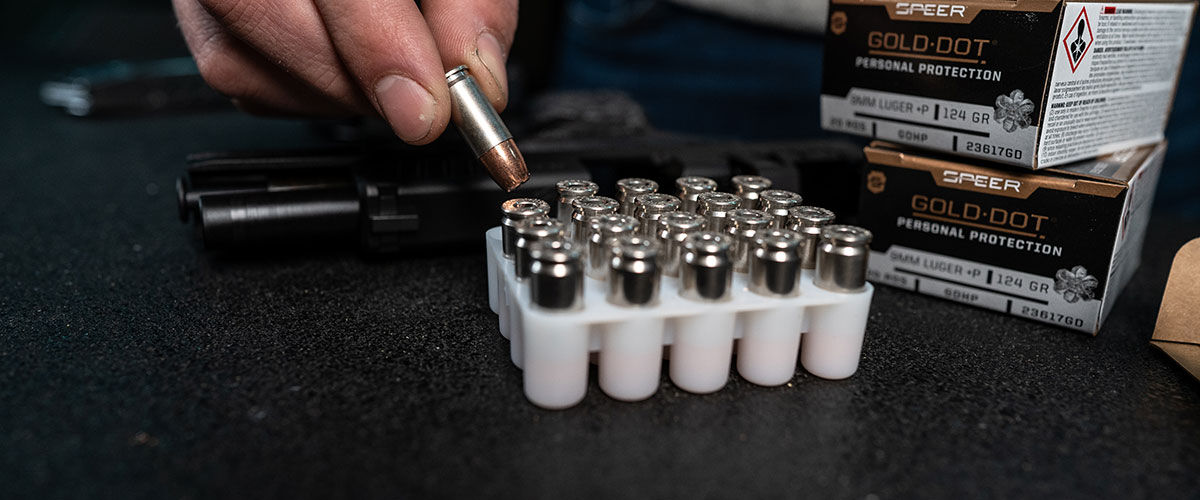 Gold Dot Personal Protection 9mm ammo being removed from container on a table