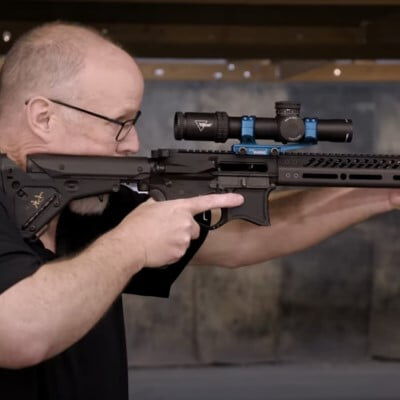 Patrick Kelley looking down the scope of a carbine