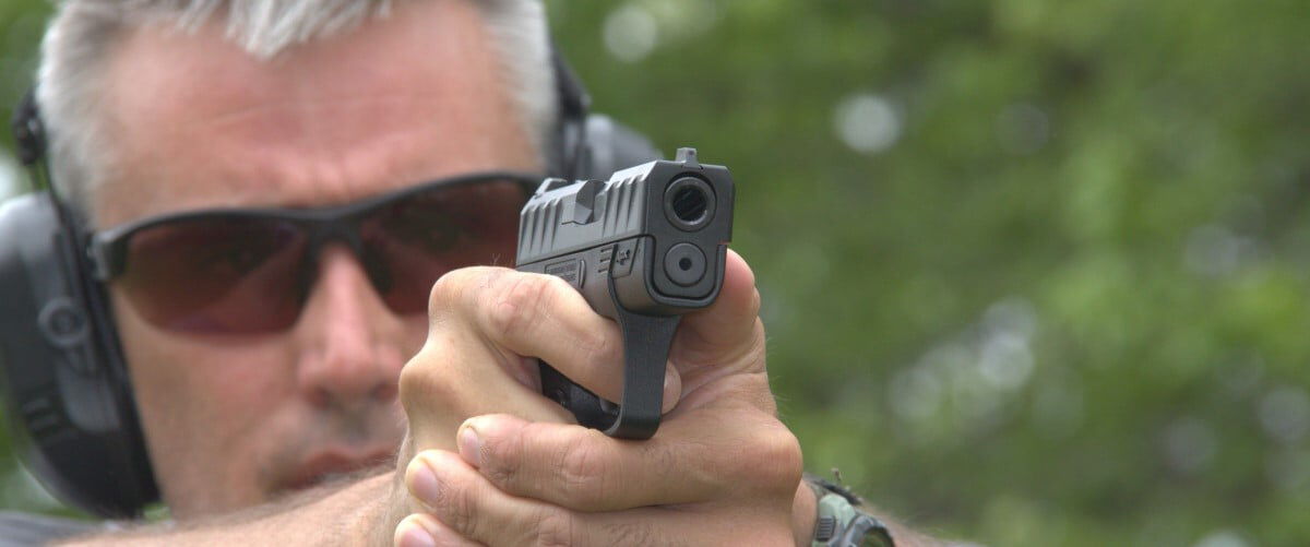 shooter looking down the iron sights on a pistol