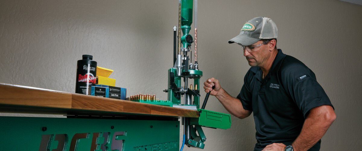 man sitting at a reloading workbench
