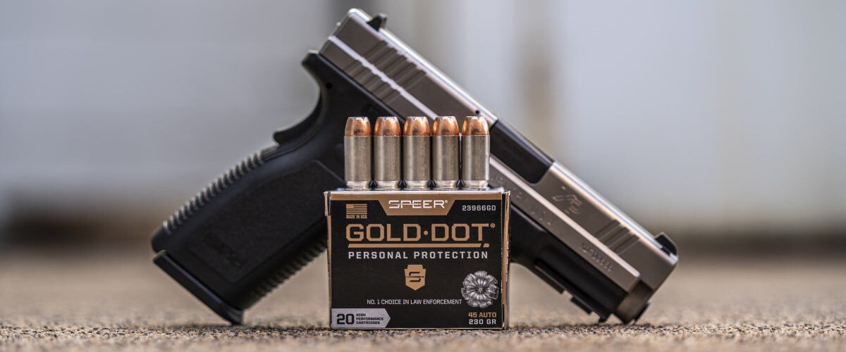 Speer Gold Dot box in front of a handgun on a table