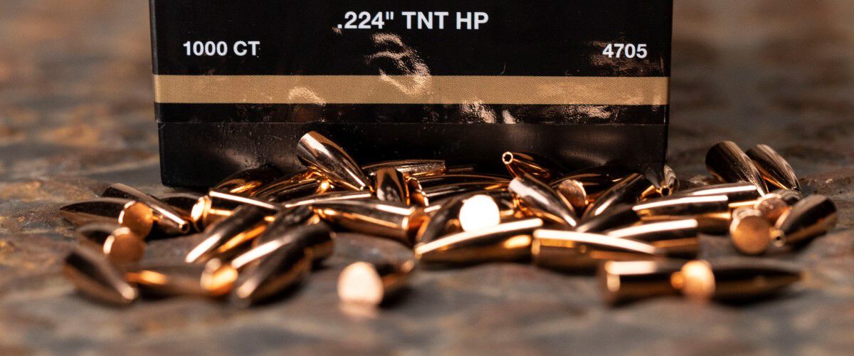 22 Caliber TNT cartridges on a table in front of a Speer TNT box