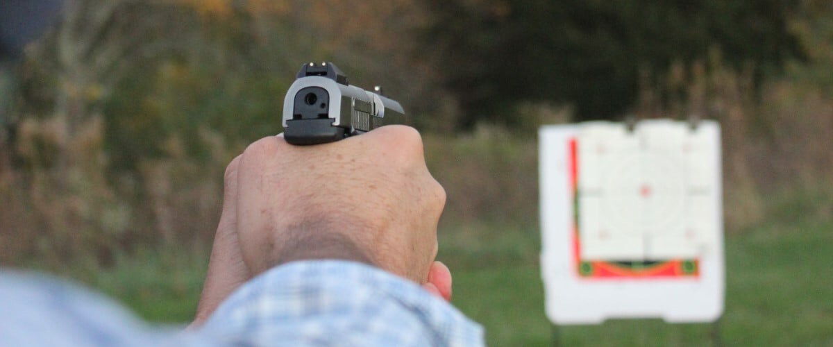 pistol being aimed at an outdoor target