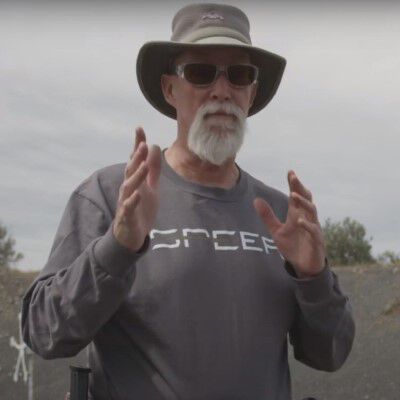 Patrick Kelley aiming a pistol while outside