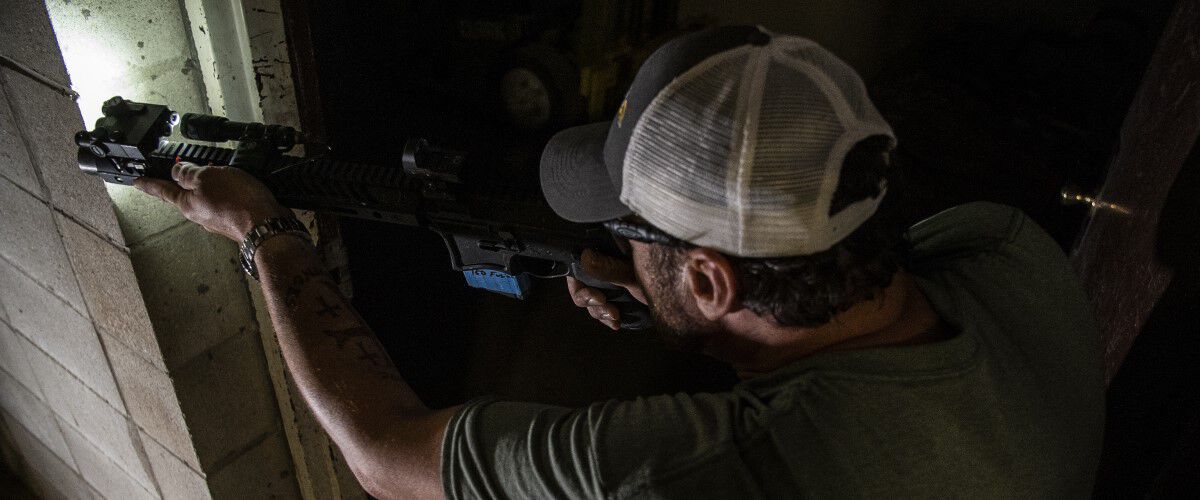 rifle being pointed around the corner in a home