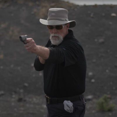 Patrick Kelley aiming pistol drawn from his pocket