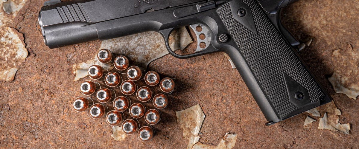 Speer Gold Dot tray next to a handgun on a table