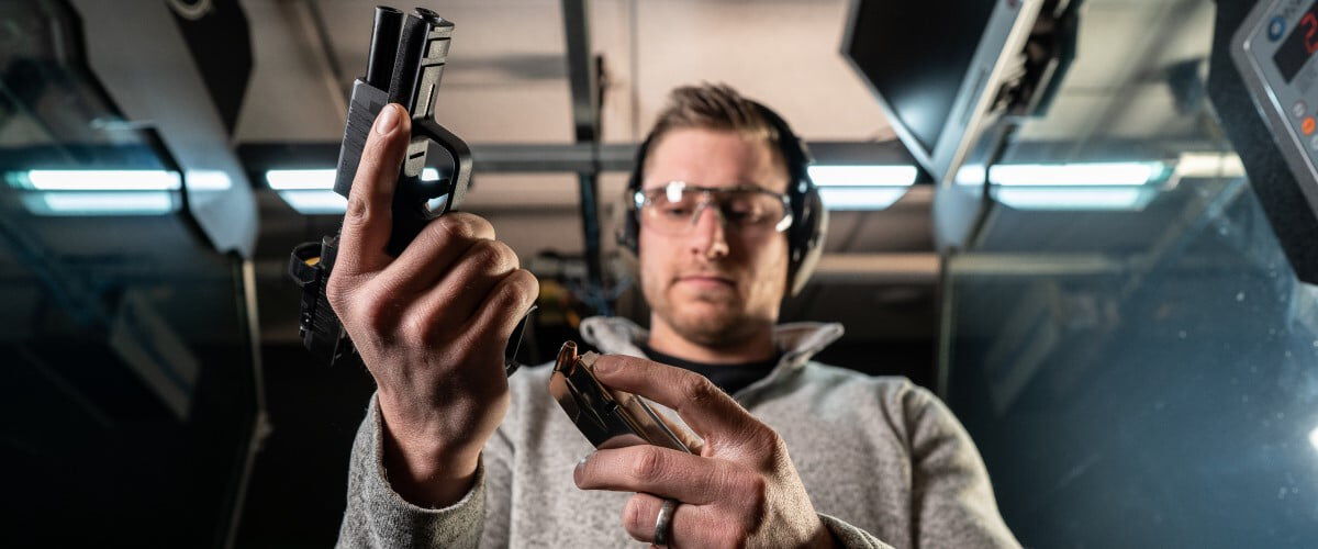 shooter loading a magazine into a pistol