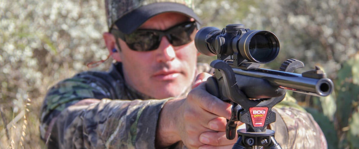 hunter looking down the scope of a handgun