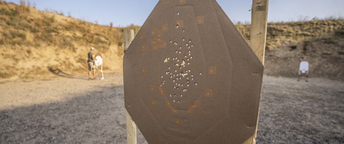 target in an outdoor range with lots of bullets holes in it