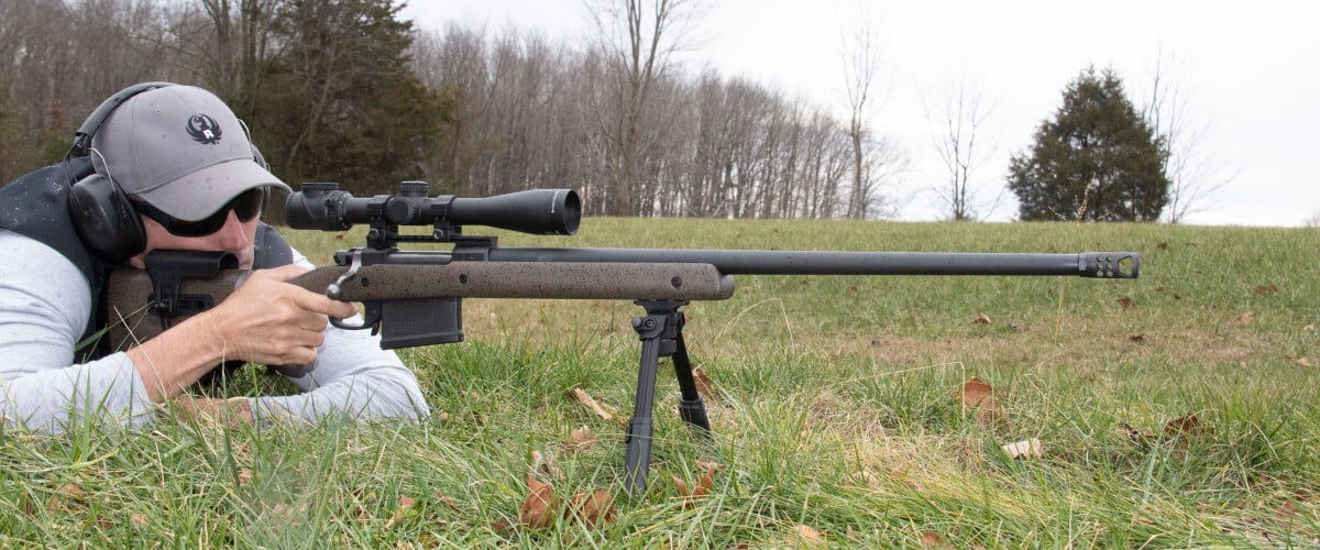 shooter in a prone position and aiming rifle on a bipod