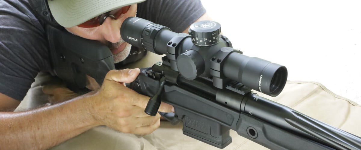 shooter looking down the scope of a rifle