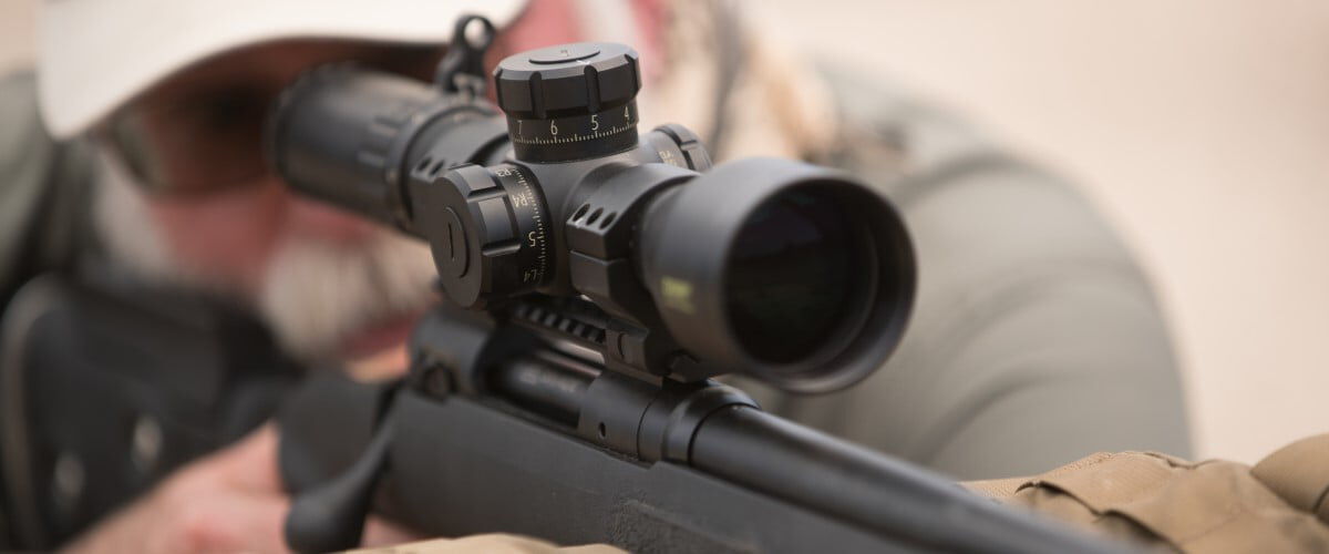 shooter looking down the scope of a rifle
