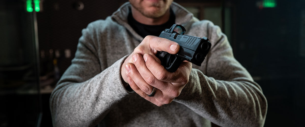 person holding handgun with both hands
