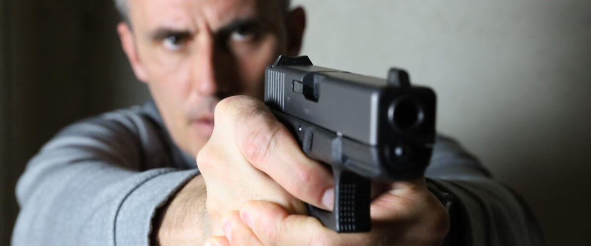 shooter looking down the iron sights of a pistol