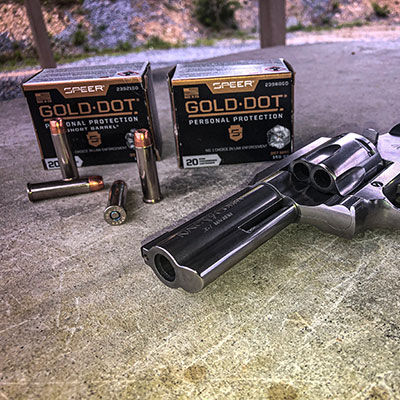 2 boxes of Gold Dot on the ground with a revolver