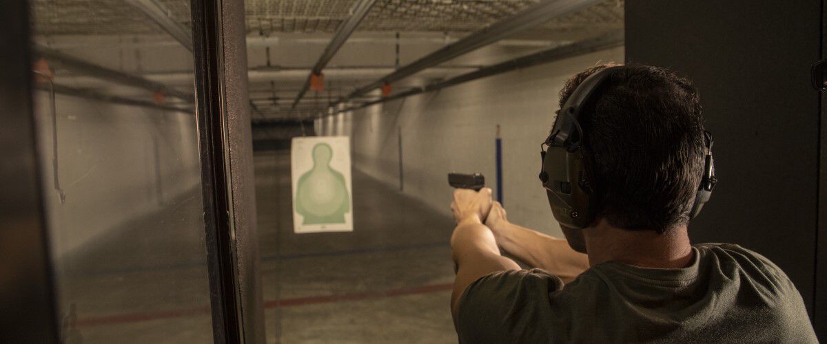 Man holding a pistol at an indoor range
