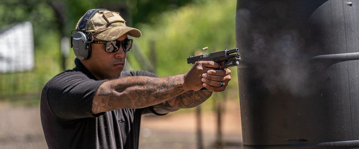 man pointing a pistol outside